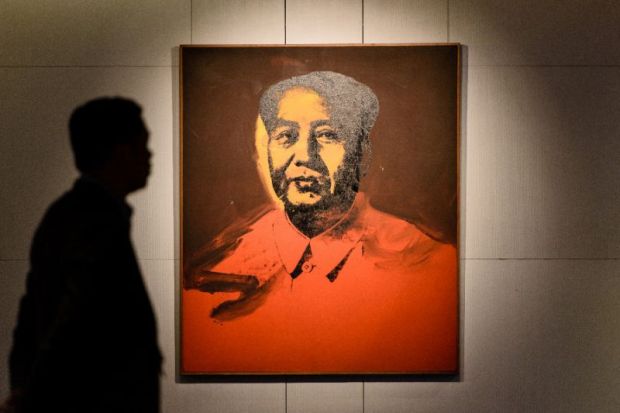 A man walks past ‘Mao’ a 1973 screen print by US artist Andy Warhol, during a pre-auction preview by Sotheby's in Hong Kong, on March 17, 2017 (AFP Photo/Anthony WALLACE)
